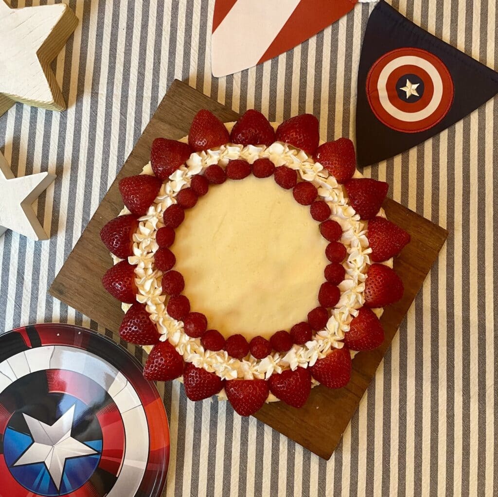 Center of Captain America Shield Cheesecake showing a whipped cream star surrounded by fresh blueberries and a ring of piped whipped cream stars.