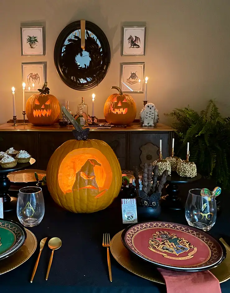 Hogwarts Halloween party tablescape with carved Sorting Hat pumpkin and house plates