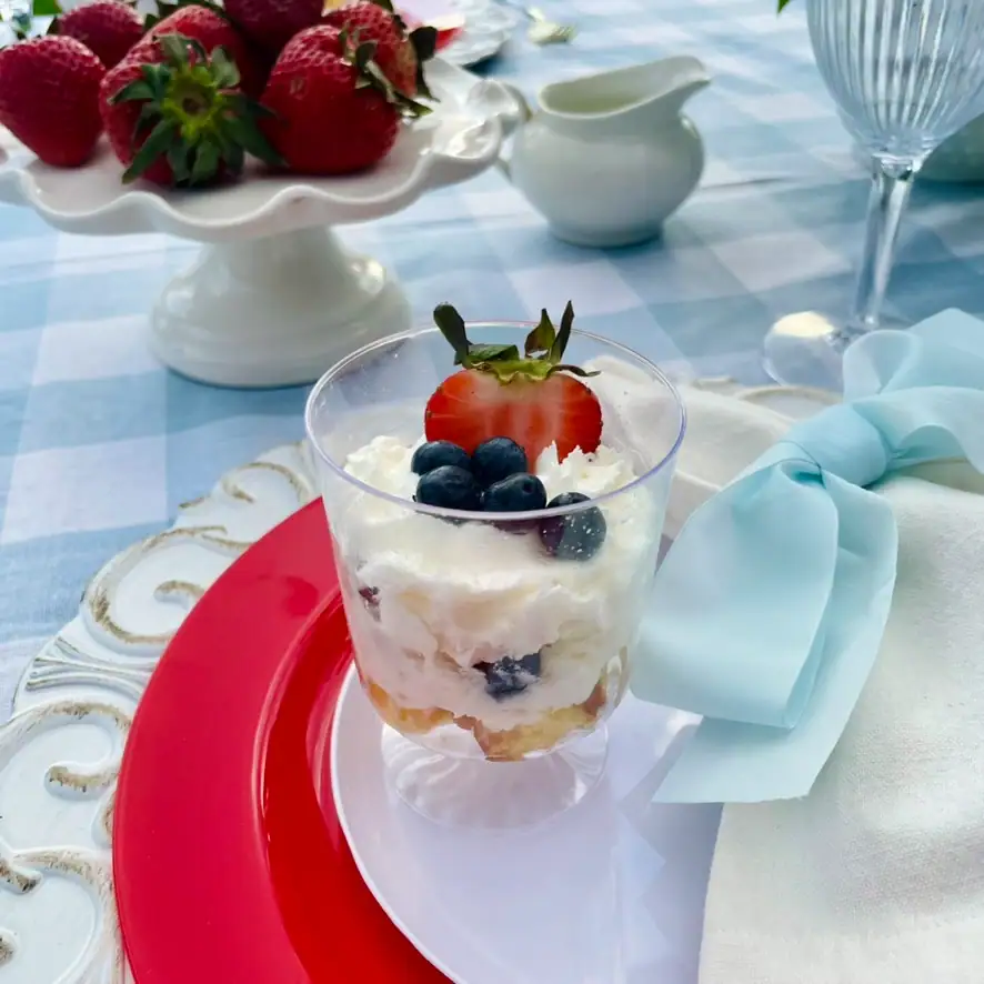 Mini berry trifle cups with whipped cream, strawberries, and blueberries on a red white and blue cottage tablescape — easy 4th of July dessert